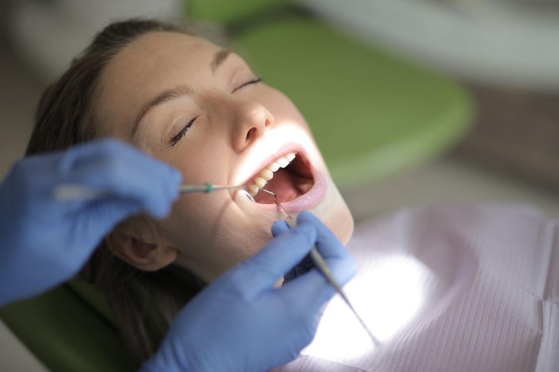 A close-up view of a dentist examining the inside of a patient's mouth