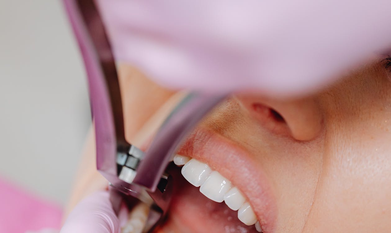 A close-up of a dental mirror being used to examine a patient's teeth