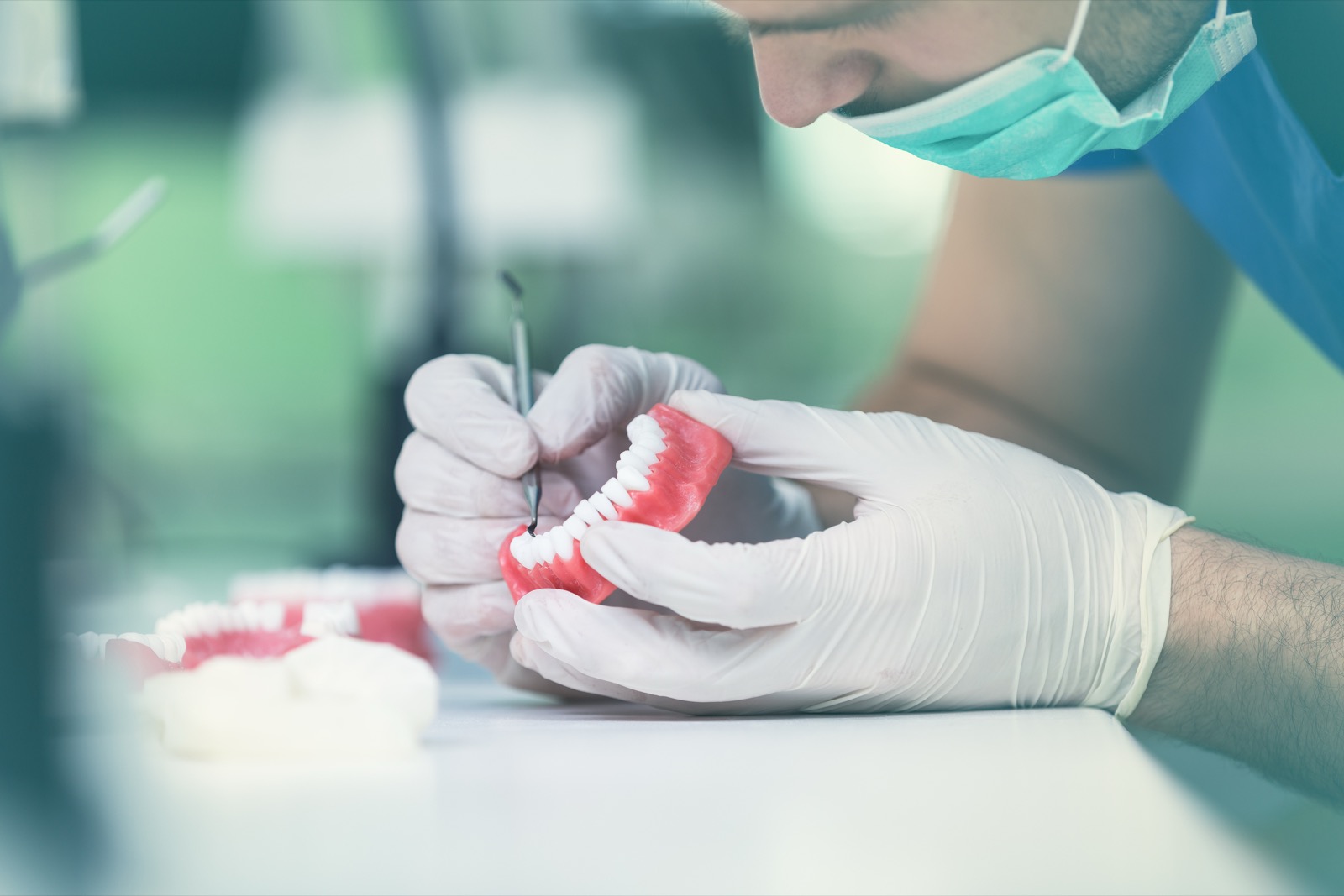 Dental technician refining a full-arch denture by hand